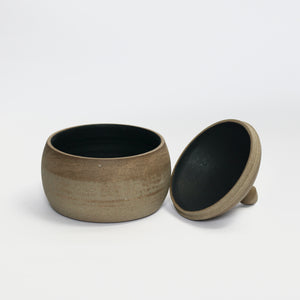 Curved, lidded pot, toasted stoneware clay. Unglazed exterior with charcoal, black glaze inside. Lid off in photograph.